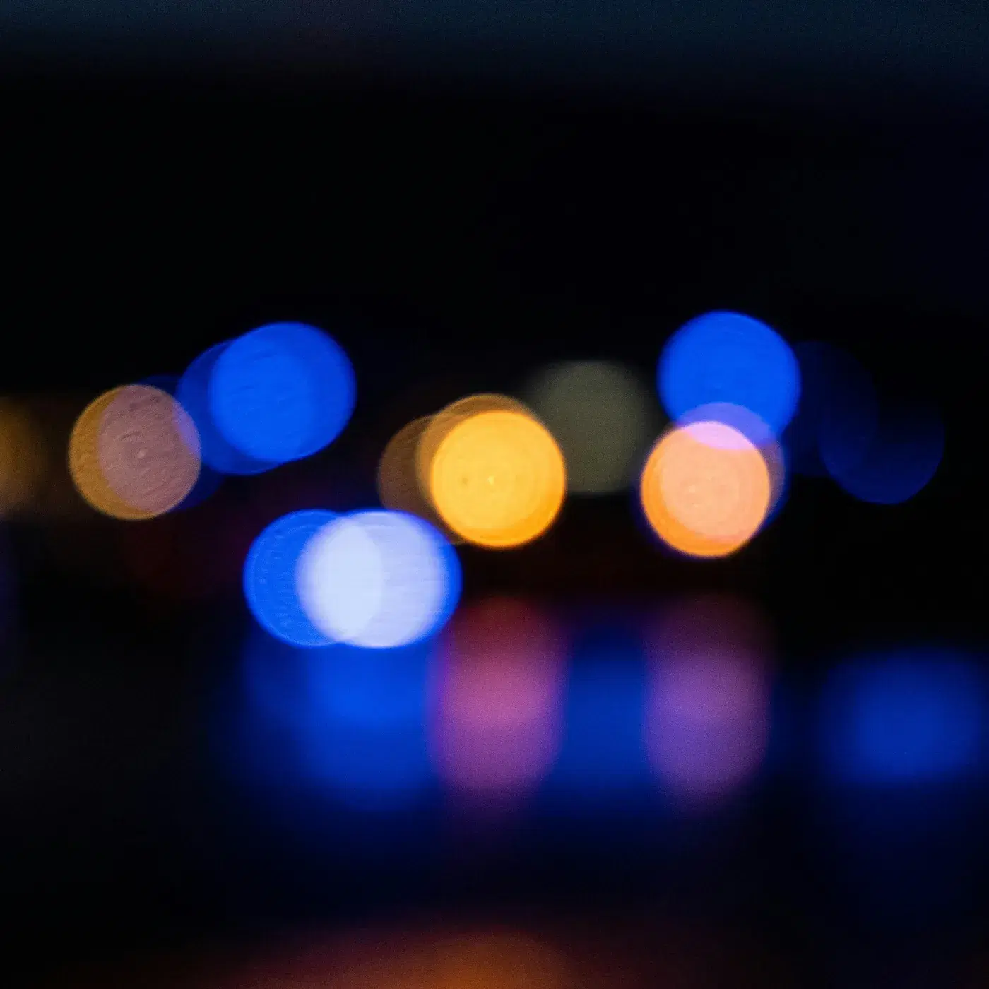 City lights at night, out of focus, in blue and amber